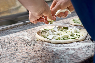 Chef prepares focaccia bread pizza baked in the oven at the market