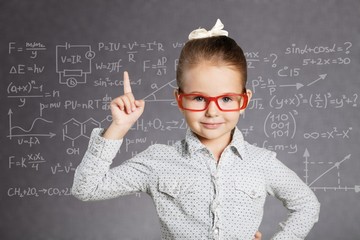 Cute little schoolgirl in glasses on  background