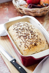 Homemade wheat bread with flax seeds in ceramic baking dish