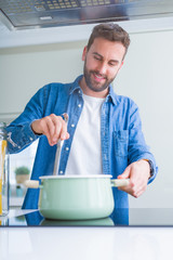 Handsome man cooking pasta at home