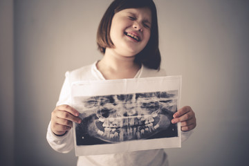 x-ray of calf's and permanent teeth in hands child