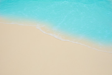 Fototapeta na wymiar Soft waves of blue sea on the Maldives beach for the background.