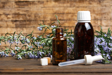 Rosemary oil in a bottle with flower branches