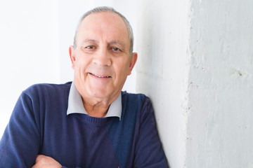 Obraz premium Handsome middle age senior man smiling cheerful, happy and positive leaning over white background with crossed arms