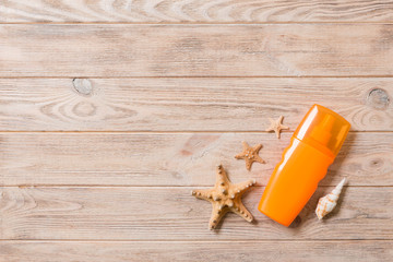 Top view of sunscreen bottle with starfish on wooden board background with copy space. flat lay concept of summer travel vacation