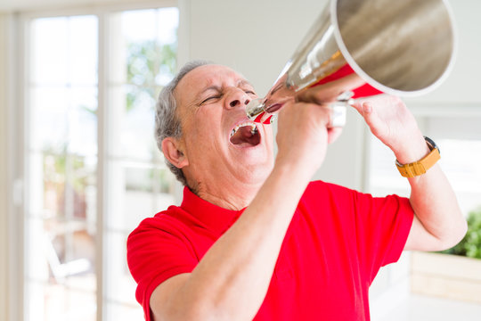 Senior man shouthing excited through vintage metal megaphone