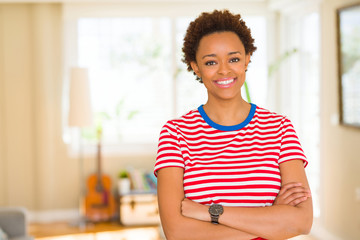 Beautiful young african american woman smiling confident to the camera showing teeth with crossed arms