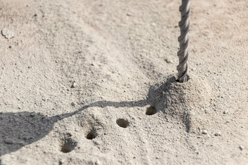 People are using electric drill,He drilled concrete to put steel anchor.