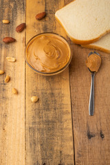 peanut butter, toast and nuts on a wooden texture, breakfast, tasty and hearty food, vertical photography, with space