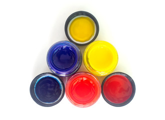 Top view of opened bottles of primary color on white background.