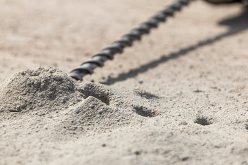 People are using electric drill,He drilled concrete to put steel anchor.