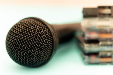 close-up microphone and audio cassettes blurred in the background