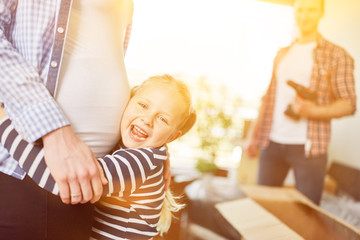 Tochter umarmt schwangere Mutter mit Babybauch