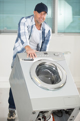 repairman carrying washing machine with hand truck