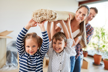 Kinder und Eltern tragen einen Teppich