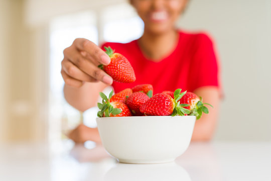 Close up of young woman eating fresh strawberries