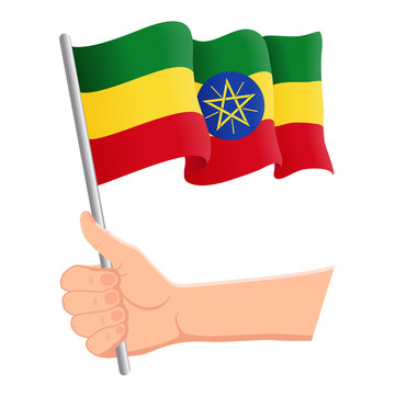 Hand holding and waving the national flag of Ethiopia. Fans, independence day, patriotic concept. Vector illustration, eps 10.