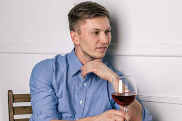 Young handsome man sitting by table in cafe while waiting for his girlfriend