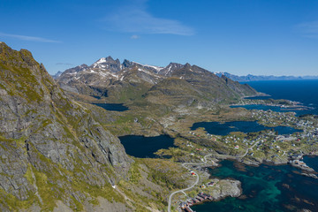 Fototapeta na wymiar Aerial view of Tind. Lofoten islands. Norway. The fishing village of Reine. Spring time in Nordland. Blue sky. View from above.