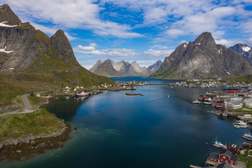 Aerial view of Reine, Lofoten islands, Norway. The fishing village of Reine. Spring time in Nordland. Blue sky. View from above.
