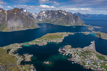 Fototapeta na wymiar Aerial view of Reine, Lofoten islands, Norway. The fishing village of Reine. Spring time in Nordland. Blue sky. View from above.