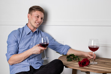 Young handsome man sitting by table in cafe while waiting for his girlfriend