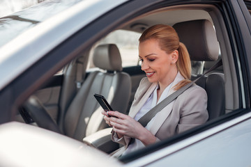 Fototapeta na wymiar Businesswoman texting in the car.