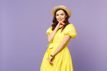 Smiling young woman in yellow dress summer hat looking camera, put hand prop up on chin isolated on pastel violet background in studio. People sincere emotions, lifestyle concept. Mock up copy space.