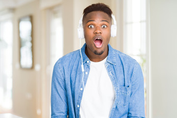 African american man wearing headphones listening to music afraid and shocked with surprise expression, fear and excited face.