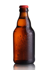 small bottle of beer with drops on a white background