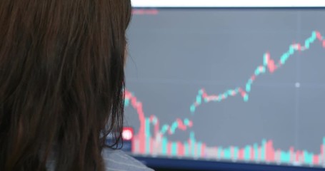 Woman check on the stock market data on the computer screen - Powered by Adobe