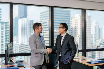 Group of young business people working and communicating while sitting at the office desk together.