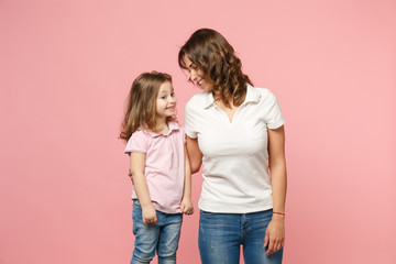 Woman in light clothes have fun with cute child baby girl. Mother, little kid daughter isolated on pastel pink wall background, studio portrait. Mother's Day, love family, parenthood childhood concept