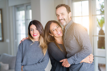 Beautiful family together. Mother, father and daughter smiling and hugging with love at home.