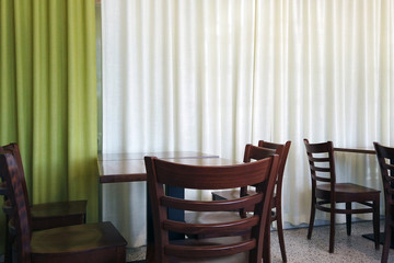 Empty wooden chairs and tables in coffee shop. Copy space.