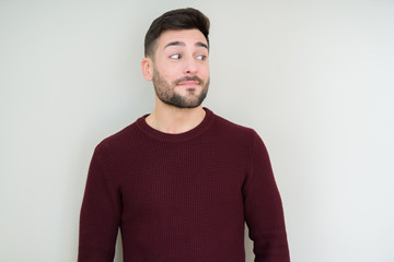 Fototapeta premium Young handsome man wearing a sweater over isolated background smiling looking side and staring away thinking.