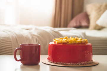 Birthday cake with one candle and red frosting. National bakery. Round cake with mango.