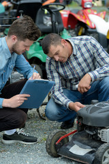 gardener trying to fix lawn mower