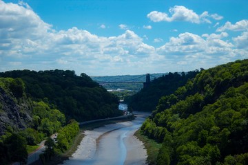 Fototapeta na wymiar Avon gorge with the clifton suspension bridge in the background with vivid blue sky and white clouds and green forest