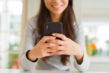 Close up of woman hands using smartphone smiling