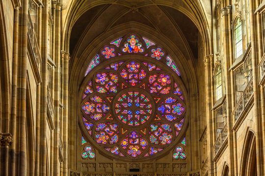 Prague, Czech Republic-February 01, 2019. Stained-glass window of main West entrance from inside the St. Vitus Cathedral. The Rose Window depicts scenes from the Biblical story of creation.