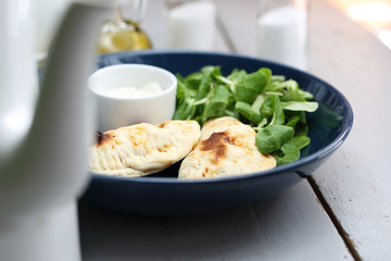Calzone with spinach filling served with garlic sauce.