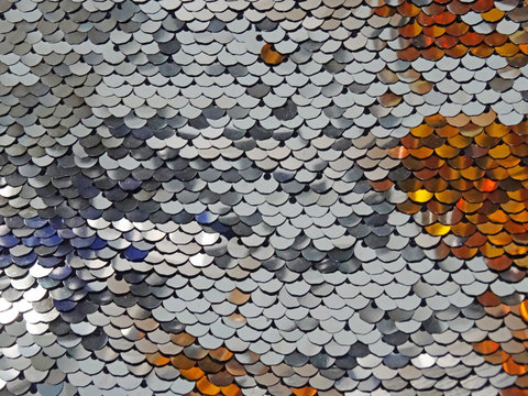 One mettalic sequin full frame photography with some variation of colors from silver colored to copper or gold. Textured scales with gold and silver colors. Close-up
