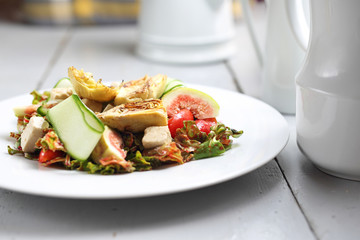 Dietary salad with figs, artichoke, cucumber, cherry tomatoes, feta on rucola leaves poured with raspberry sauce.
