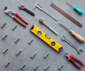 Set of hand tools on a gray background, top view.