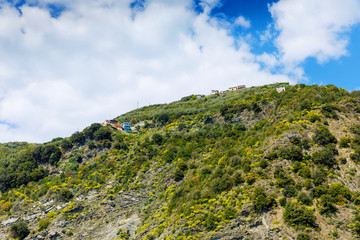 Liguria, Italy coastline of Riviera with colorful houses on sunny warm day. Monterosso al Mare, Vernazza, Corniglia, Manarola and Riomaggiore, Cinque Terre National Park UNESCO World Heritage