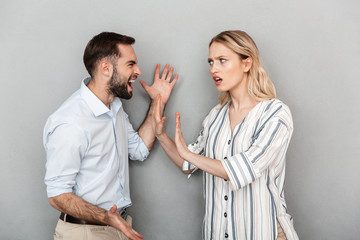 Photo of irritated couple man and woman in casual clothes having problems and arguing