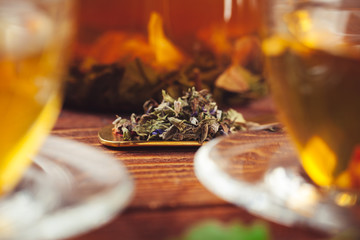 glass teapot with cup of black tea on wooden table