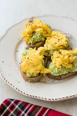 Scrambled Eggs with Avocado on Toast Bread for Breakfast.