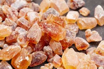 brown sugar rock organic crystalline close up on dark background